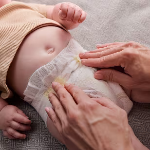 Mother fastening a diaper on her baby