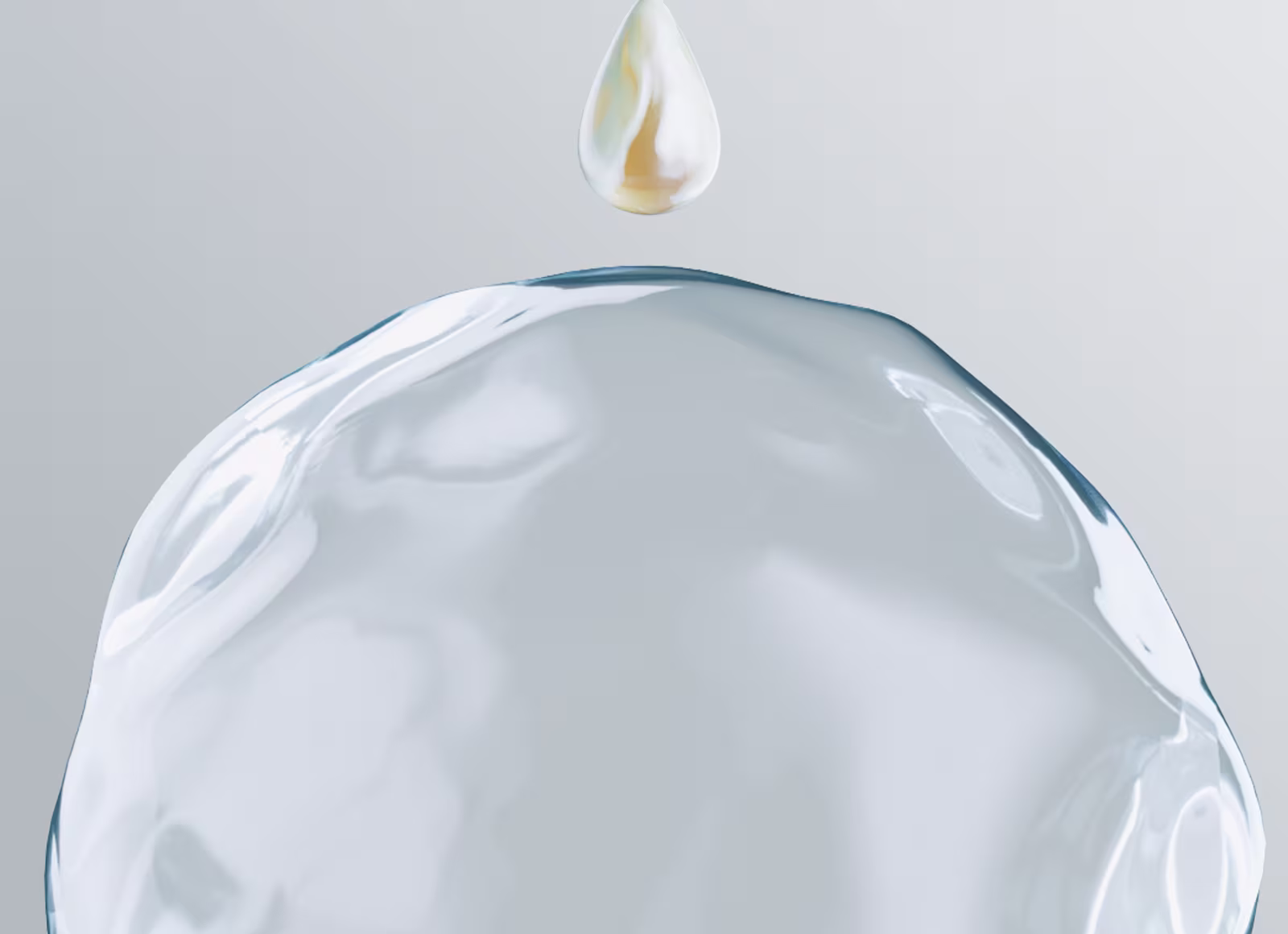 Une goutte brillante et dorée de lotion flotte au-dessus d’une goutte d’eau claire et pure.
