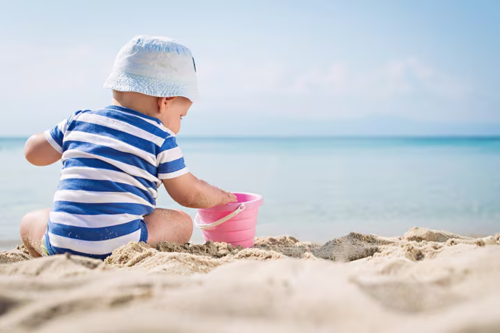 Μωράκι παίζει με κουβαδάκι στην παραλία