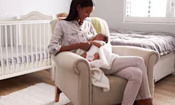 Mother holding her newborn baby, highlighting essential items for newborn care