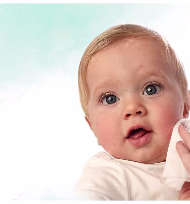 Et nærbilde av et spedbarns ansikt mens en hånd forsiktig tørker kinnet deres med en Pampers Harmonie Aqua-wipe. Et nærbilde av et spedbarns ansikt mens en hånd forsiktig tørker kinnet deres med en Pampers Harmonie Aqua-wipe.
