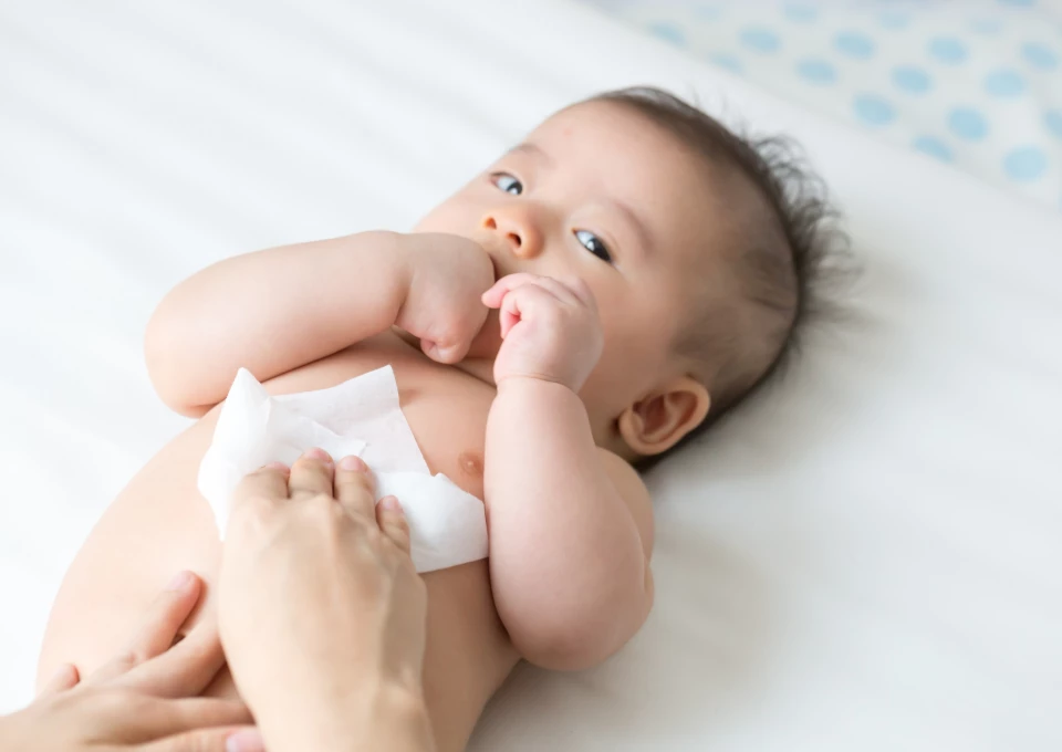 Mamãe limpando seu bebê com lencinhos umedecidos