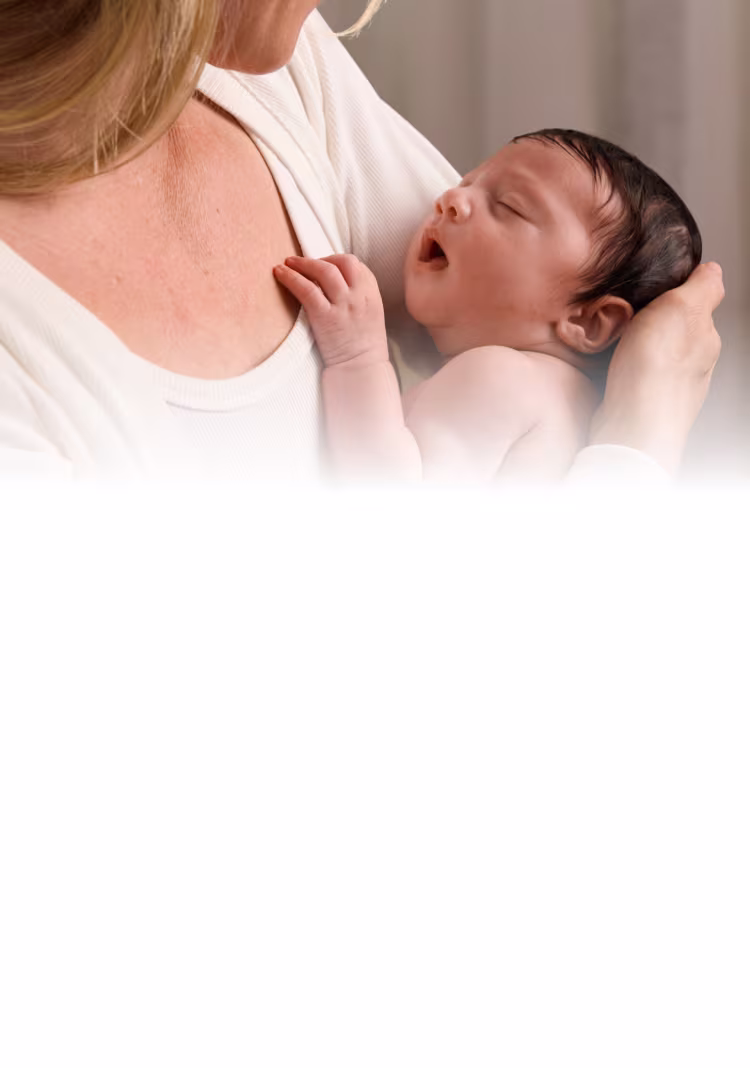 Foto de uma mãe segurando seu recém-nascido.