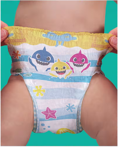 A baby wears a Baby Shark-themed swim diaper with blue and white stripes and colorful shark characters, with hands gently holding the sides.