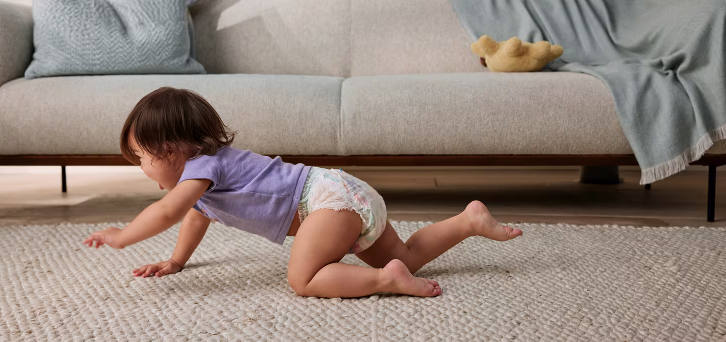 Baby crawling wearing a diaper.