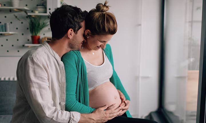 Couple attendant un bébé – futur papa touchant le ventre de sa femme enceinte