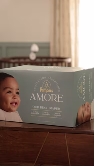 A box of AMORE diaper sitting on a wooden console in a warm lit nursery