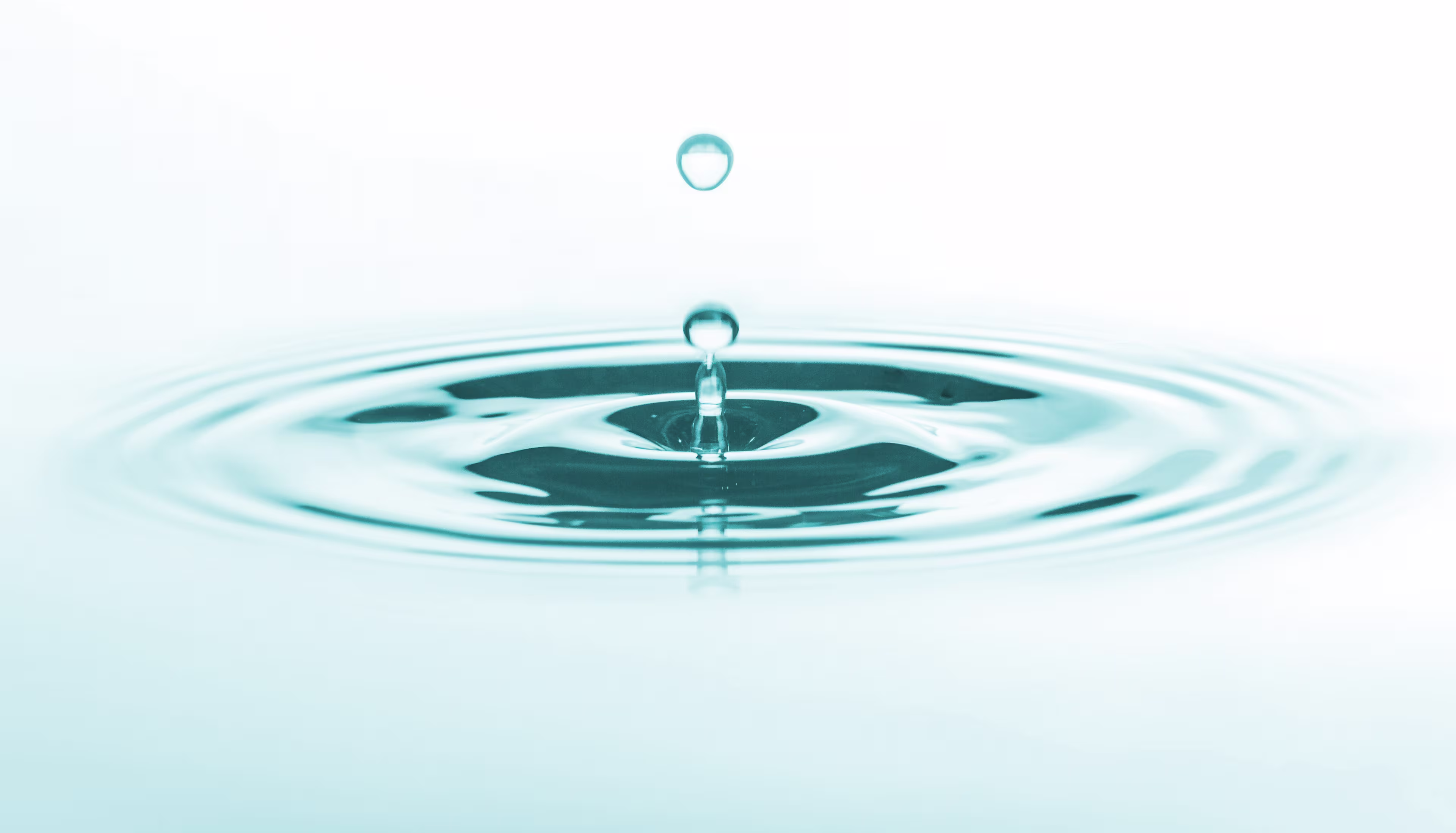 Un acercamiento de una gota de agua creando una onda