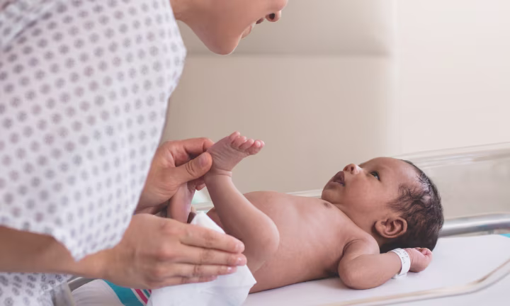 Inhaltsstoffe in Pampers Feuchttüchern: Mutter reinigt ihr Neugeborenes Baby mit Feuchttüchern.