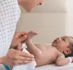 Inhaltsstoffe in Pampers Feuchttüchern: Mutter reinigt ihr Neugeborenes Baby mit Feuchttüchern.