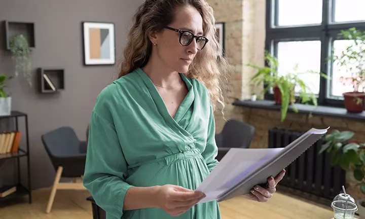 Eine schwangere Frau informiert sich über die Einträge im Mutterpass
