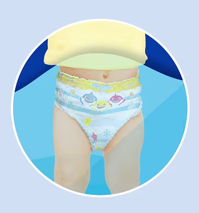 Mostra-se um bebé a usar uma fralda de natação com o tema do Baby Shark, visto da cintura para baixo numa vista circular recortada.