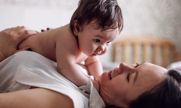 Una madre compartiendo con su bebé, posiblemente sufriendo de mastitis