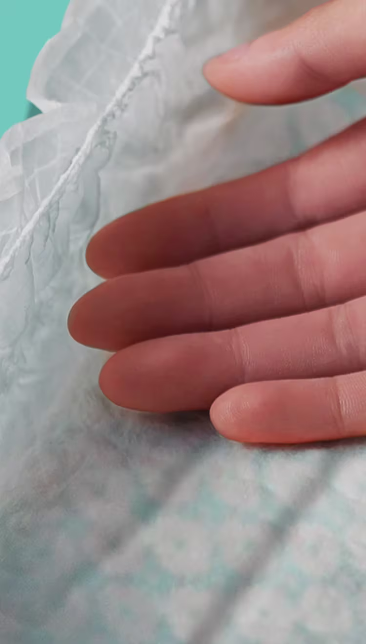 Ultra Suave. Mano tocando el pañal suave