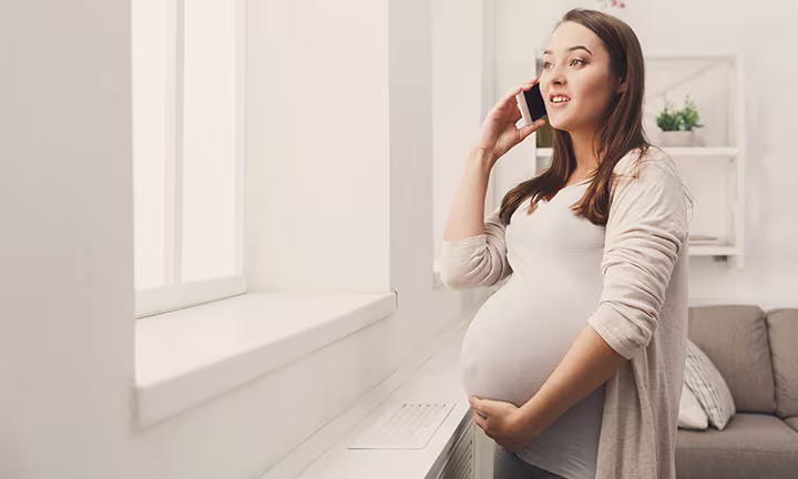 Femme enceinte au téléphone car elle a perdu les eaux