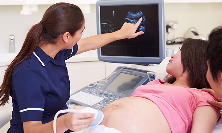 Healthcare professional conducting an ultrasound for an expectant mother, highlighting pregnancy care.