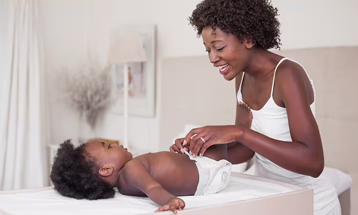 A woman changing her baby's diaper