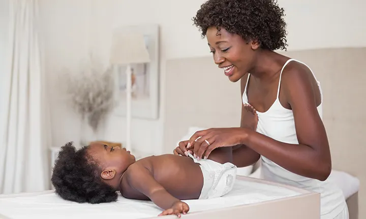 A woman changing her baby's diaper