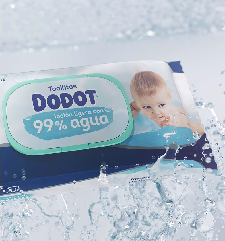Uma imagem em plano aproximado de uma embalagem de toalhitas para bebé Dodot 99% água, a salpicar água limpa.