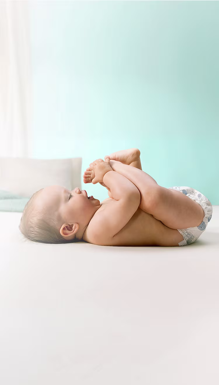 Ajuda a Prevenir Assaduras. Bebê deitado.