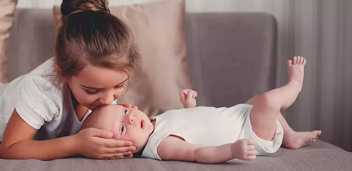Irmã beijando o irmão recém-nascido