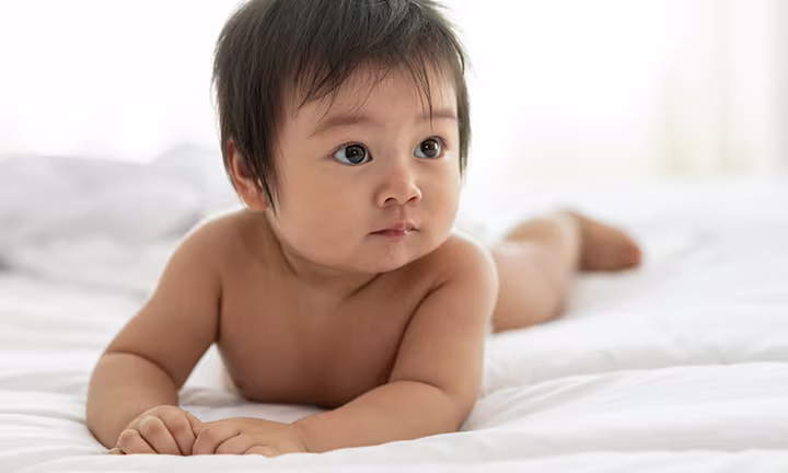 Koreanisches Baby liegt auf Bett