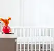 A crib and toys in a room set up for safe sleep