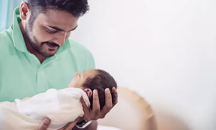 Vater hält Baby im Arm