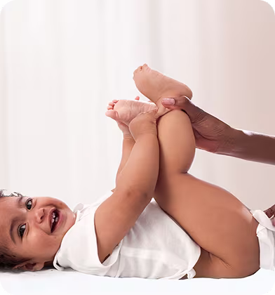 Le bébé est allongé sur le dos et est nettoyé délicatement avec une lingette humide.