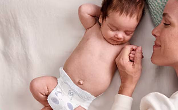 Foto de una madre acariciando a su bebé recién nacido.