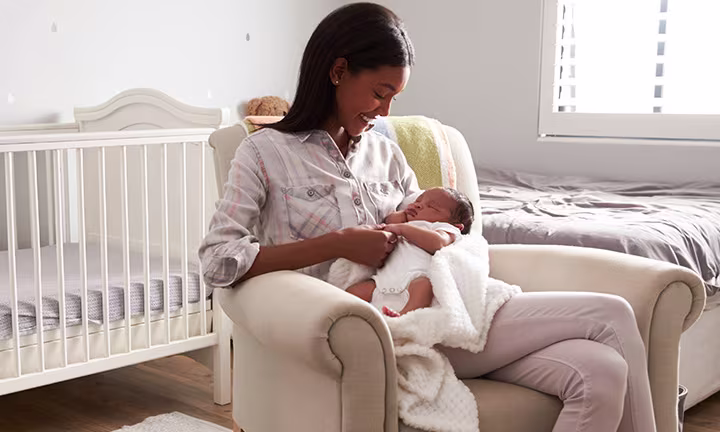 Una madre acunando a su bebé con objetos para cuidar de un recién nacido