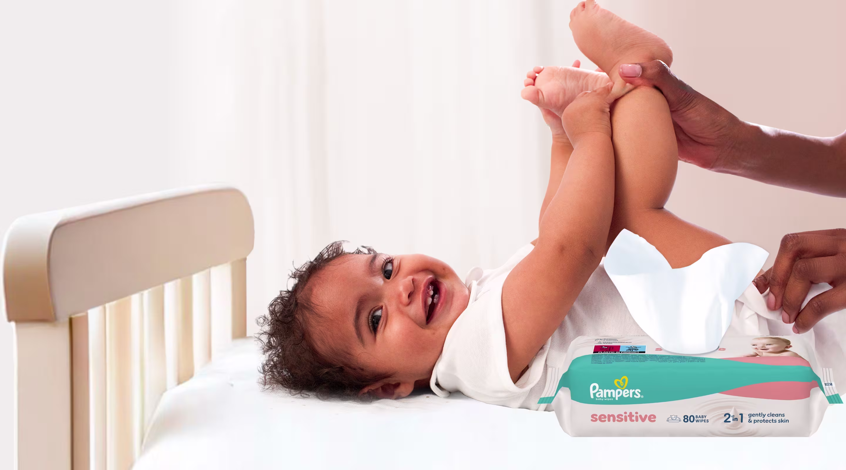 Imagine cu un bebeluș care se uită în partea dreaptă. Acesta este șters la funduleț de cu un șervețel.