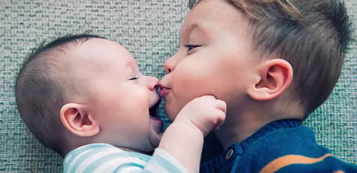Irmão mais velho beijando irmão mais novo
