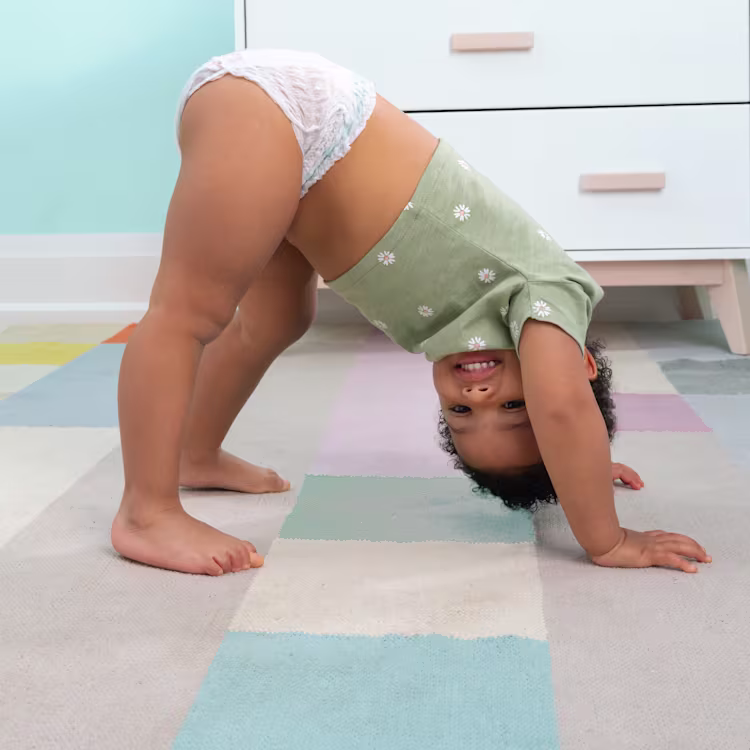 Playful toddler in Pampers pull on diaper