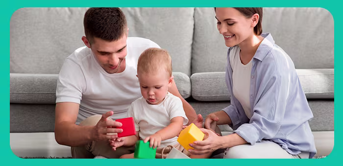 Familia feliz con juegos para bebés en casa