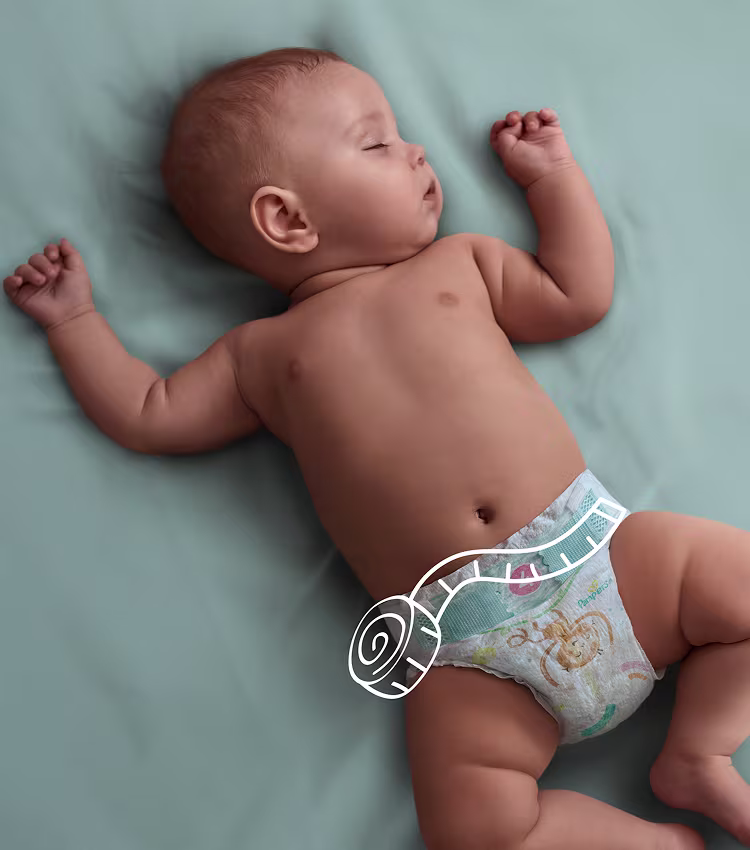 Baby som sover i sängen, med en linjal över blöjans midja.