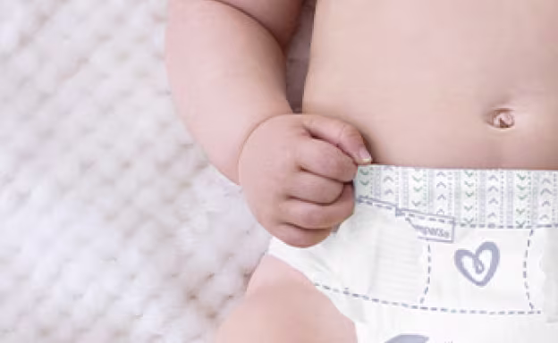 Bebê com fralda Pampers Premium Care para pele delicada.