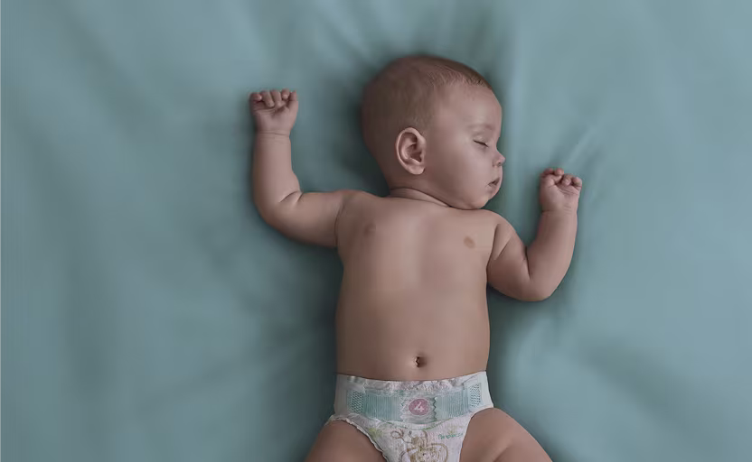 Baby sover i spjälsäng