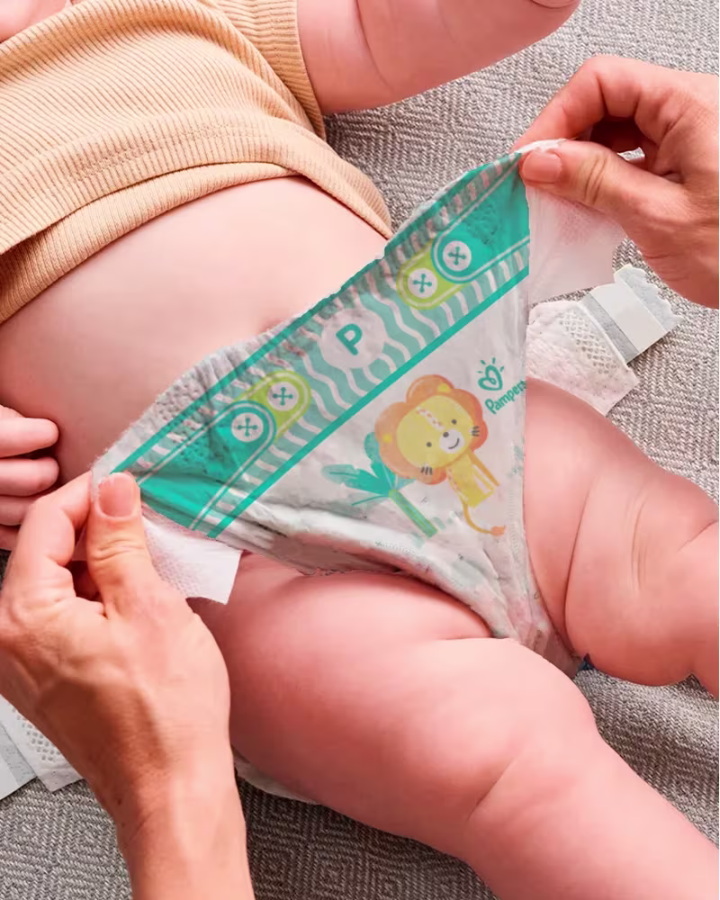 Mamá sacando el pañal del bebé.