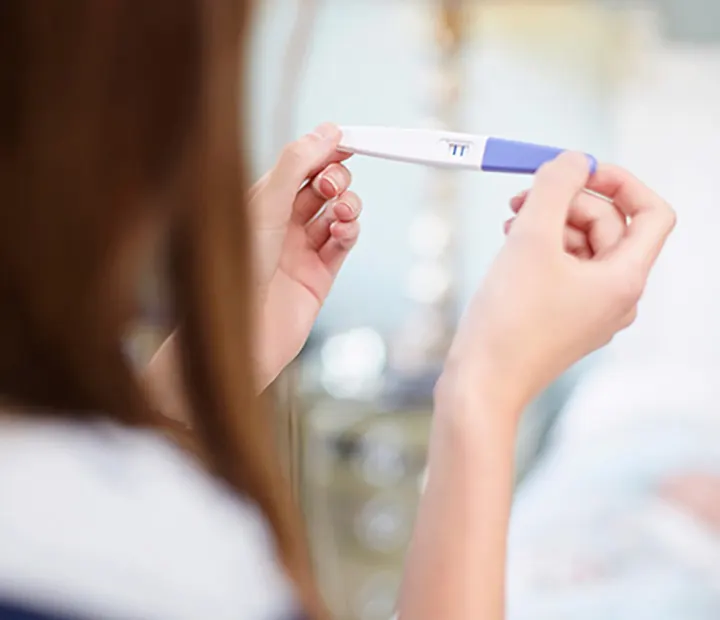 Person holding a positive pregnancy test, symbolizing the start of a joyful parenting journey.