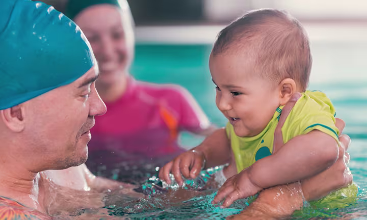Baby in a pool wearing Swim Diapers