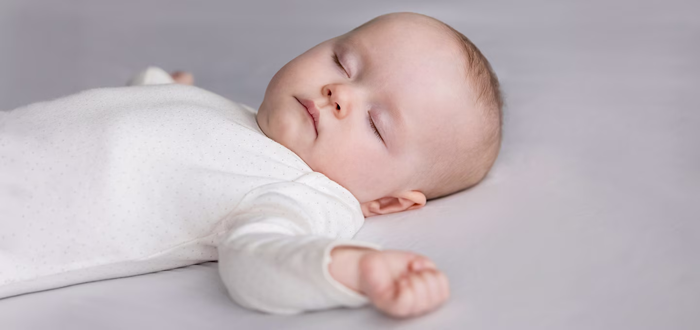 Baby in white bodysuit dreaming