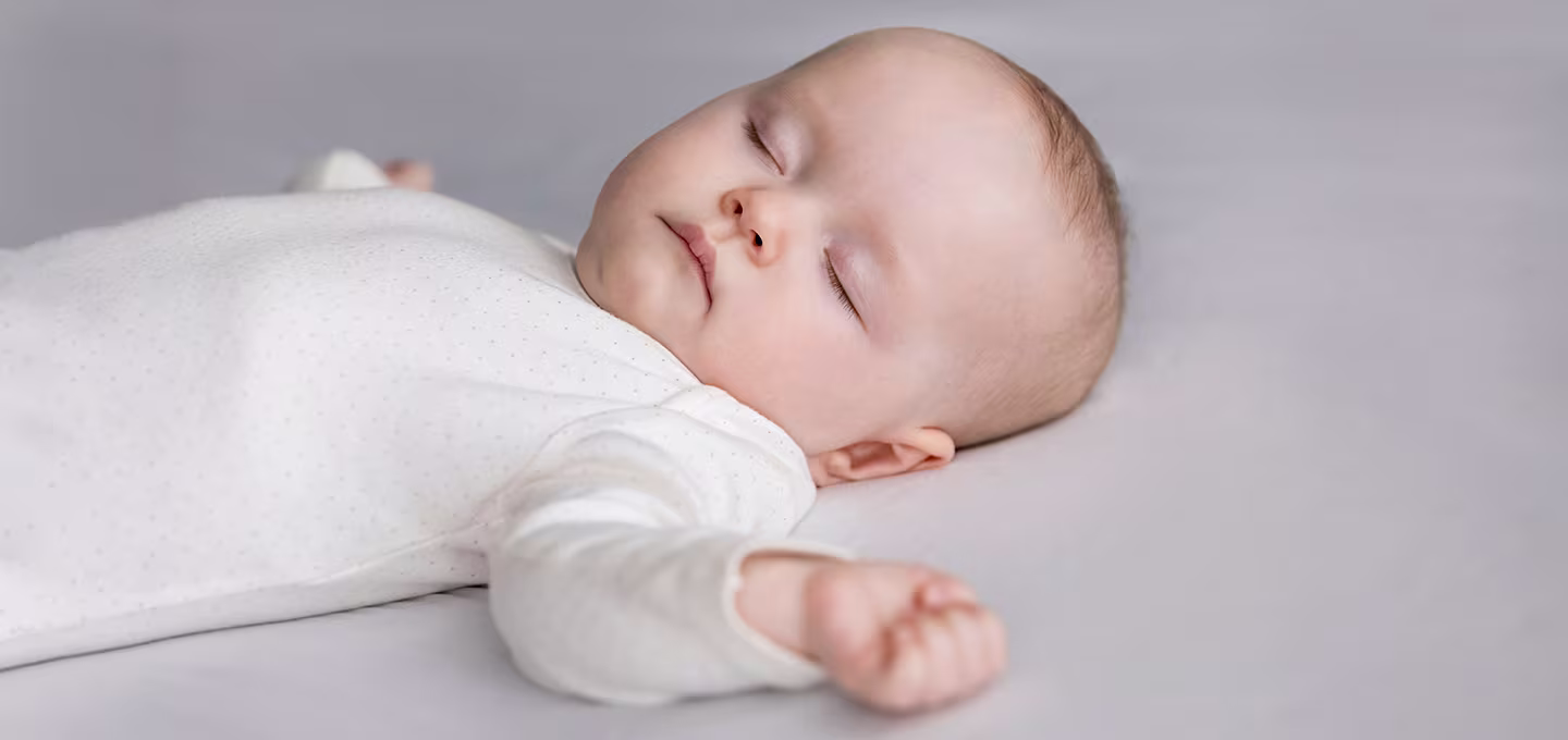 Baby in white bodysuit dreaming