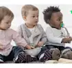 3 BABYS SITZEN AUF DEM TEPPICH