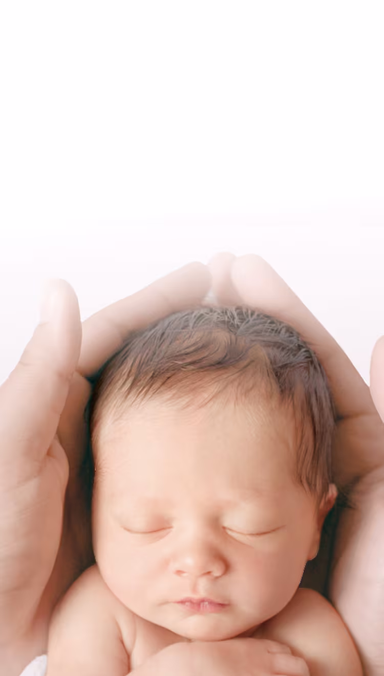2 handen houden voorzichtig het hoofdje van een pasgeboren baby vast.