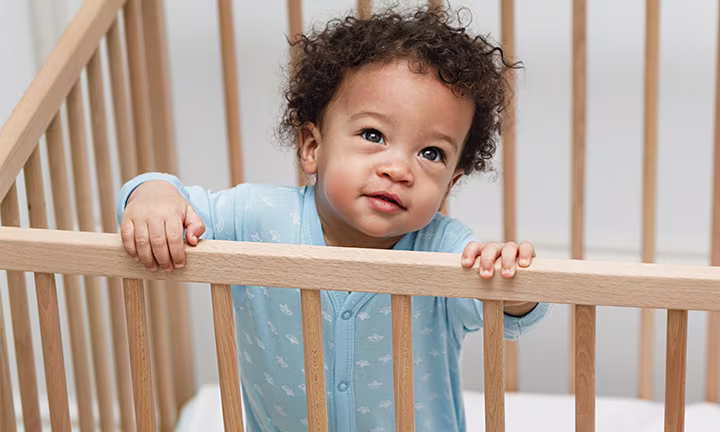 Baby boy standing in crib