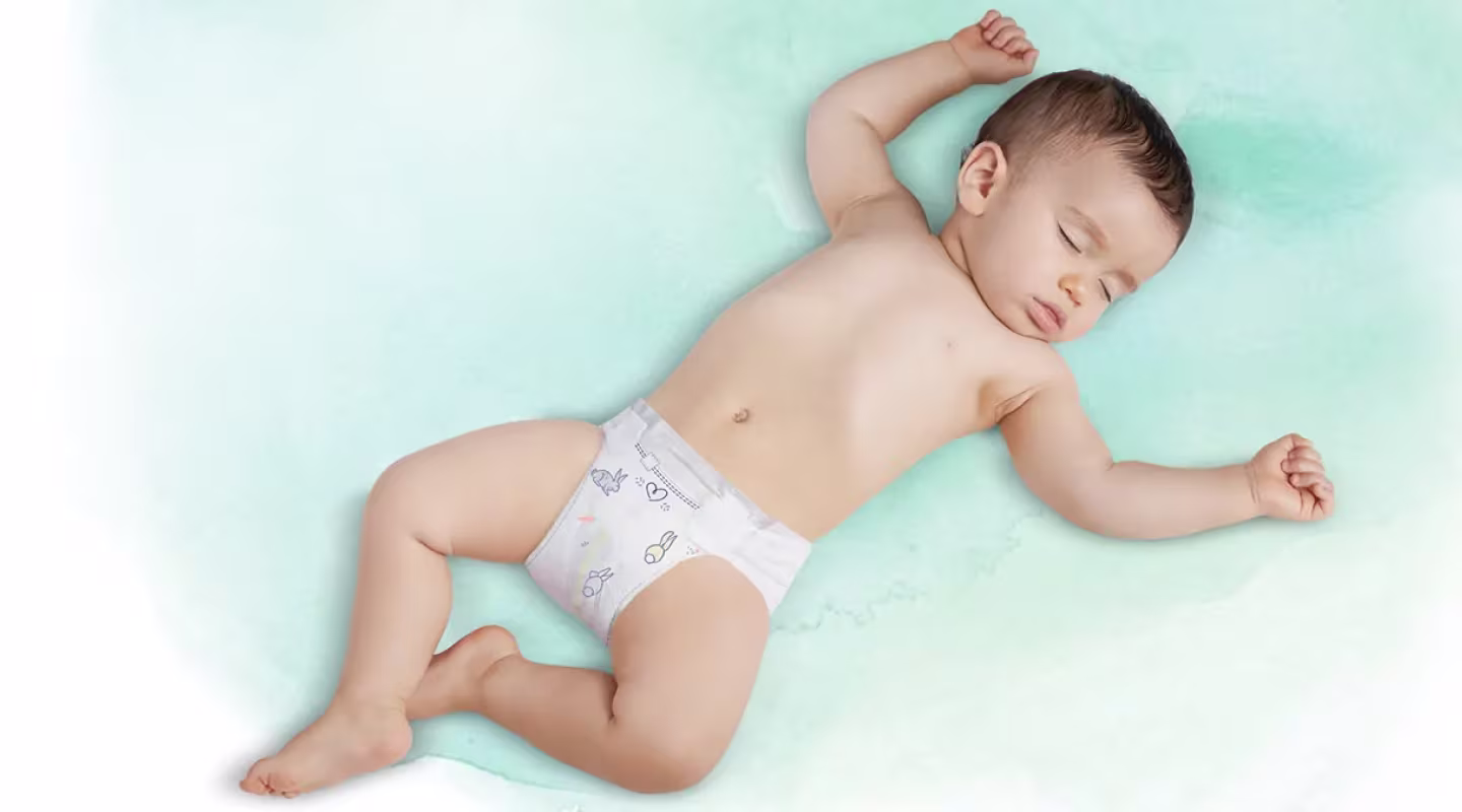 Ένα παιδί που κοιμάται ανάσκελα, με πάνα Pampers.