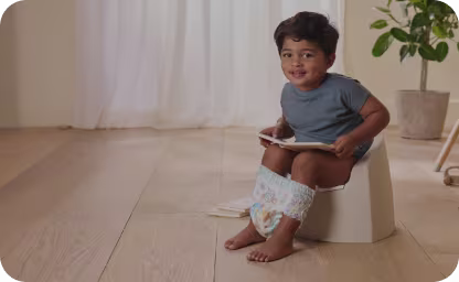 Toddler sitting on potty wearing Pampers Easy Ups