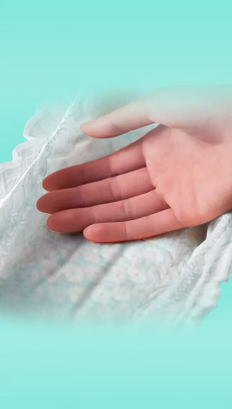 Ultra Suave. Mão tocando a fralda macia