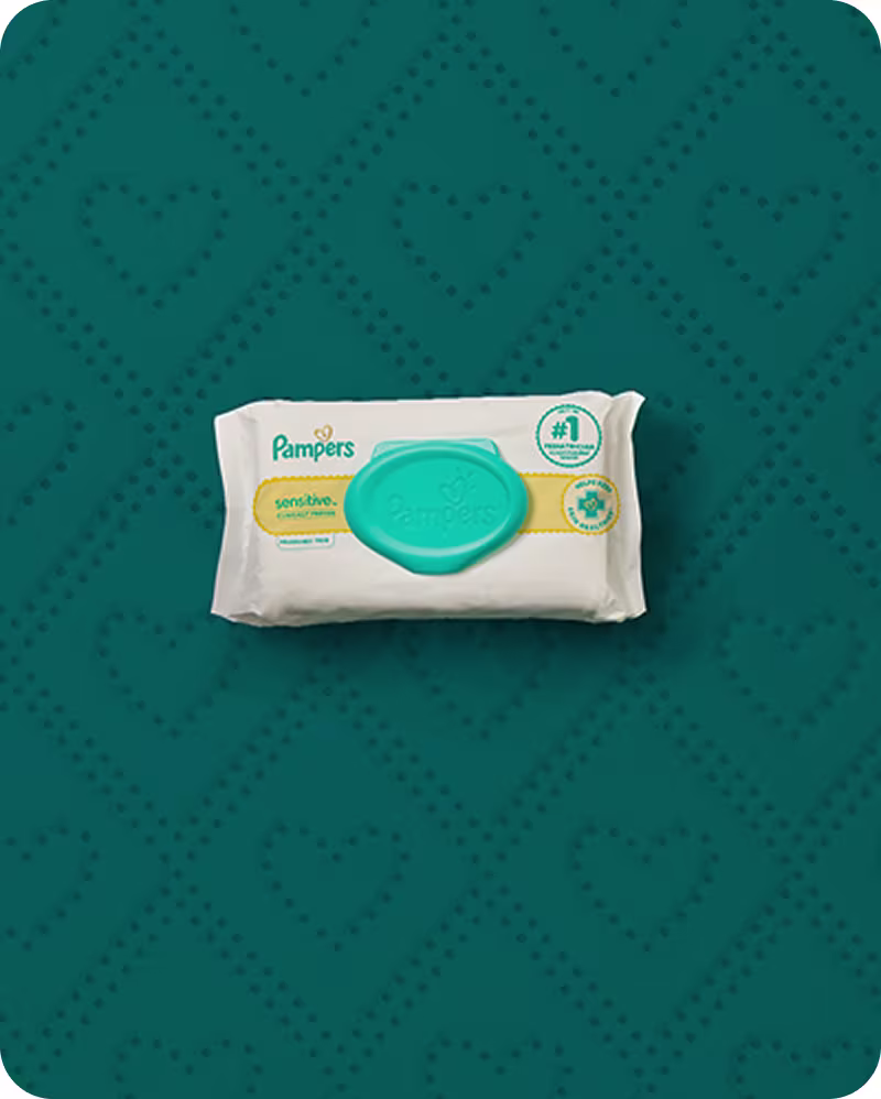 A pack of pampers sensitive wipes laying on a dark teal background